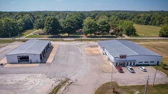 A building on left that is a 9,879 square foot shop and another building on the right that is a former dealership with offices and showroom that is 15,000 square feet located on 21.79 acres of land in Jonesboro, Arkansas at 5511 South Stadium Boulevard