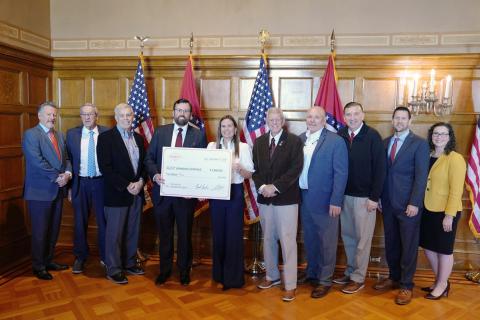 Vice President Steven Lamm of Jonesboro Unlimited holding a large check for $2 million dollars with Governor Sarah Huckabee Sanders and other Arkansas Legislators